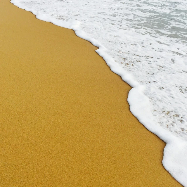 a sandy beach next to a body of water, pexels, plasticien, mustard, foamy waves, light tan, ultra detailed