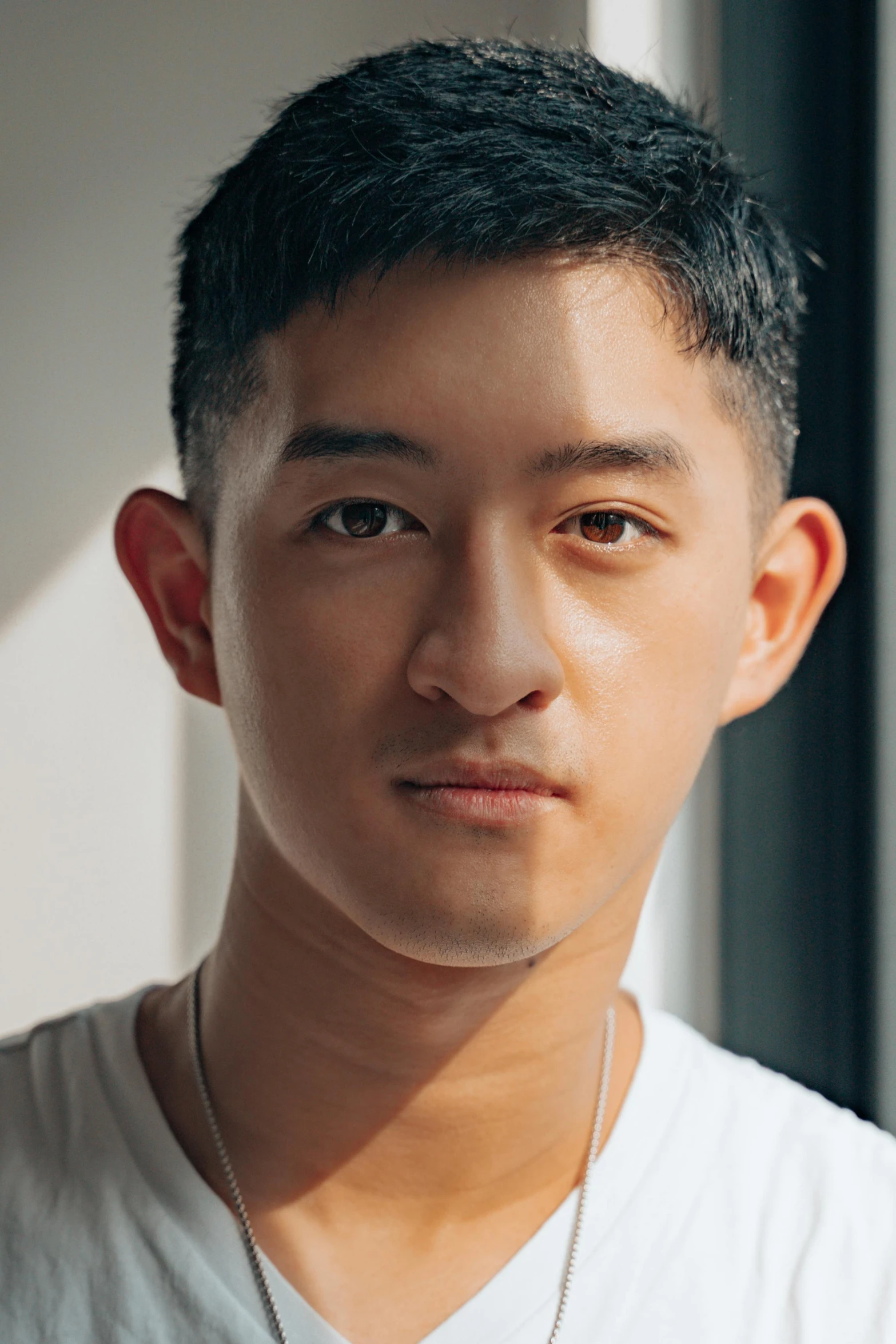 a close up of a person wearing a white shirt, inspired by Joong Keun Lee, lean man with light tan skin, darren quach, looking straight to camera, morning lighting