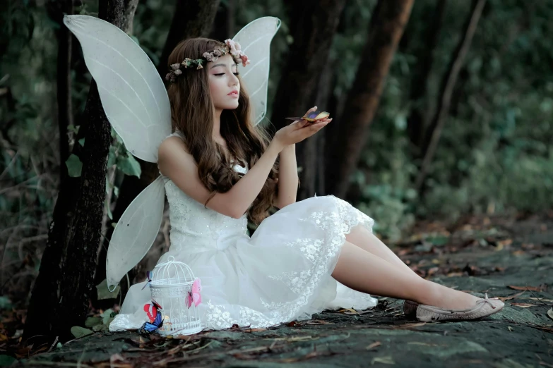 a woman dressed as a fairy sitting on the ground, trending on pixabay, beautiful south korean woman, white, small, uploaded