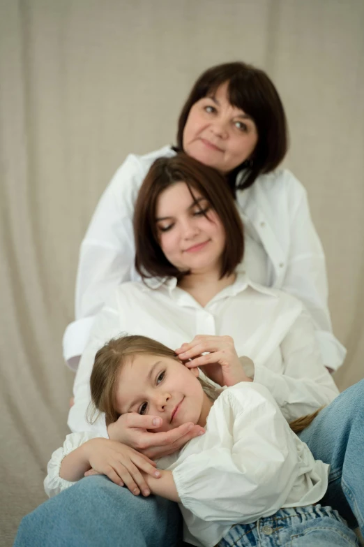 a woman sitting next to a little girl on a couch, a picture, by Attila Meszlenyi, soft studio lighting, three women, white shirts, taken in 2 0 2 0