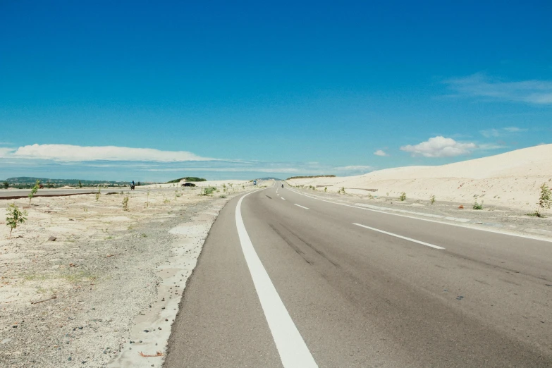 an empty road in the middle of the desert, by Eglon van der Neer, unsplash, postminimalism, white sand beach, clear blue skies, profile image, reunion island