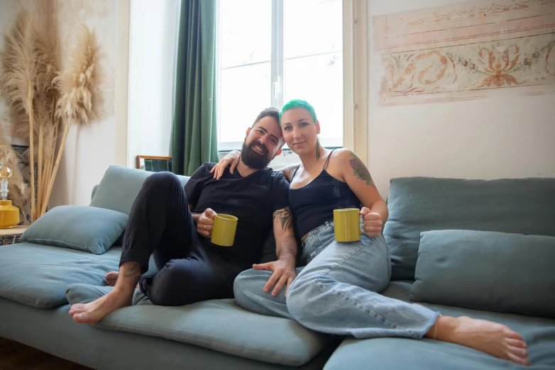 a man and a woman sitting on a couch, pexels contest winner, antipodeans, two cups of coffee, non binary model, avatar image, tattooed