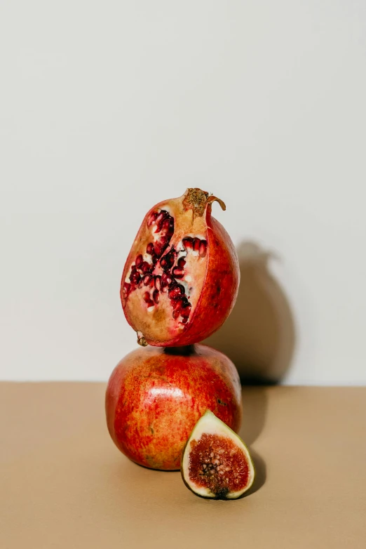 two pomegranates stacked on top of each other, a still life, trending on pexels, confident pose, facing front, opening shot, tall shot