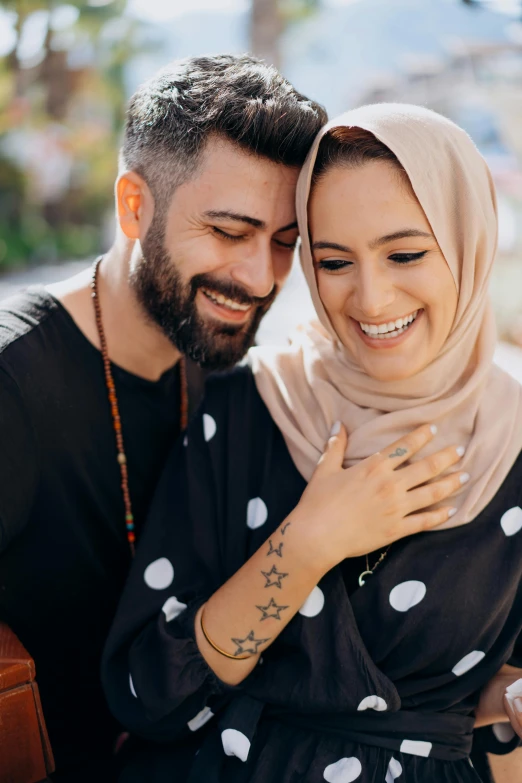 a man and a woman sitting next to each other, pexels contest winner, hurufiyya, arm around her neck, beautiful arab woman, smiling sweetly, square