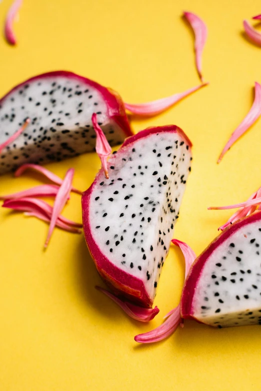 a dragon fruit cut in half on a yellow surface, by Carey Morris, pexels, hurufiyya, magenta and gray, made of food, chinese, speckled