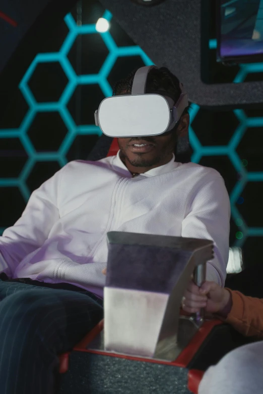 a man sitting in a chair with a laptop in his lap, a hologram, afrofuturism, wearing vr goggles, with people inside piloting it, mkbhd, “hyper realistic