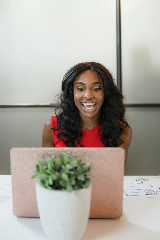 a woman sitting at a table with a laptop, mkbhd, she is smiling and excited, professional modeling, sza