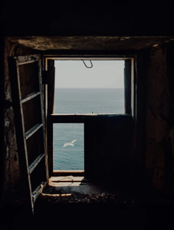 an open window with a view of the ocean, by Elsa Bleda, unsplash contest winner, natural prison light, battered, slide show, lookout tower