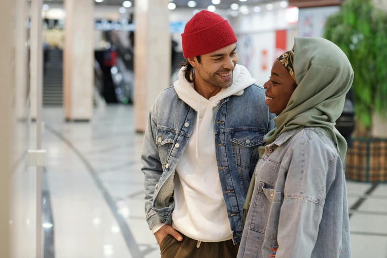 a man and a woman standing next to each other, trending on pexels, hurufiyya, at a mall, wearing a beanie, aida muluneh, romantic lead