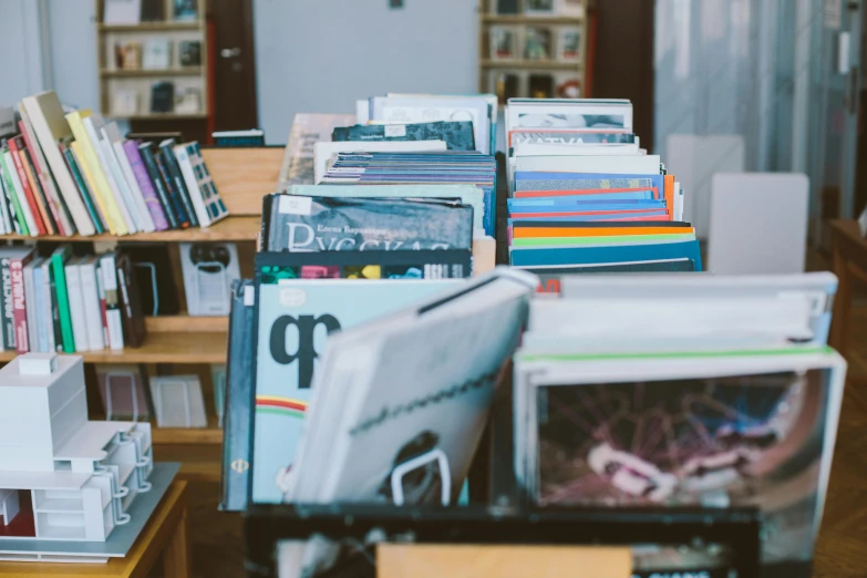 a pile of books sitting on top of a wooden table, an album cover, unsplash, spiral shelves full of books, magazine sales, thumbnail, no watermarks