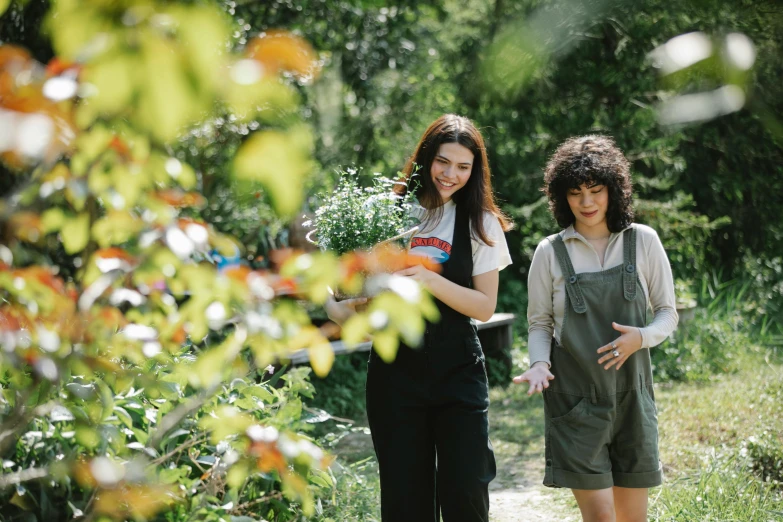 a couple of women standing next to each other, by Julia Pishtar, pexels contest winner, gardening, wearing overalls, lorde, promotional image