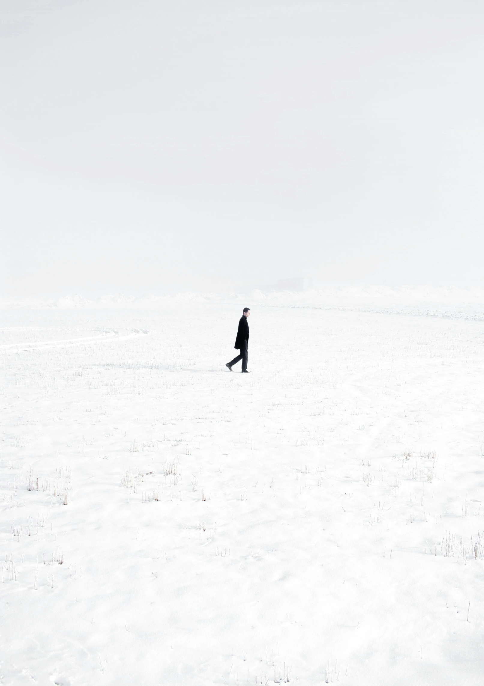 a man walking across a snow covered field, a picture, by Zsolt Bodoni, minimalism, saatchi art, alexander abdulov, man in black, small