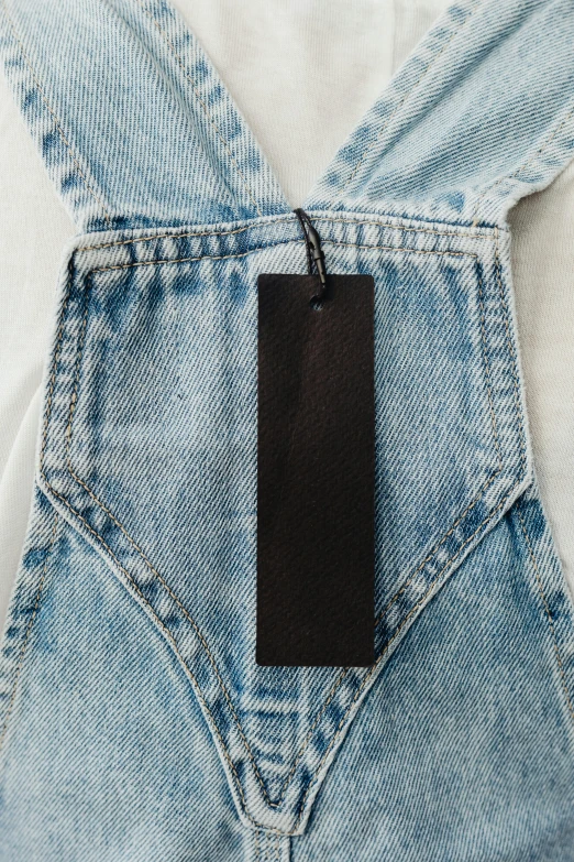 a pair of jeans with a tag hanging from the back, by Nina Hamnett, happening, leather bunny costume bodysuit, zoomed out, label, high view