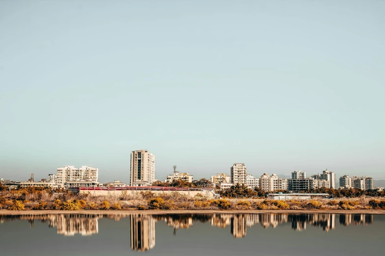 a body of water with buildings in the background, by Lee Loughridge, unsplash, cities of mesopotamia, suburb, photographic print, panoramic