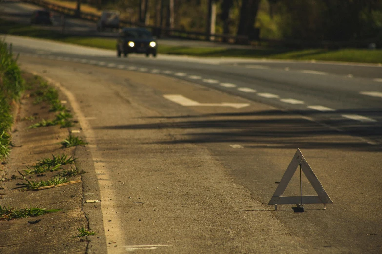 a triangle sign sitting on the side of a road, a tilt shift photo, by Eglon van der Neer, car crash, on a hot australian day, alessio albi, today\'s featured photograph 4k