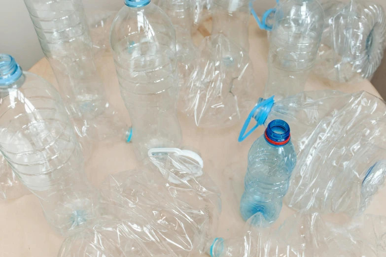 a bunch of plastic bottles sitting on top of a table, an album cover, unsplash, plasticien, profile image, vincent maréchal, hydration, upcycled