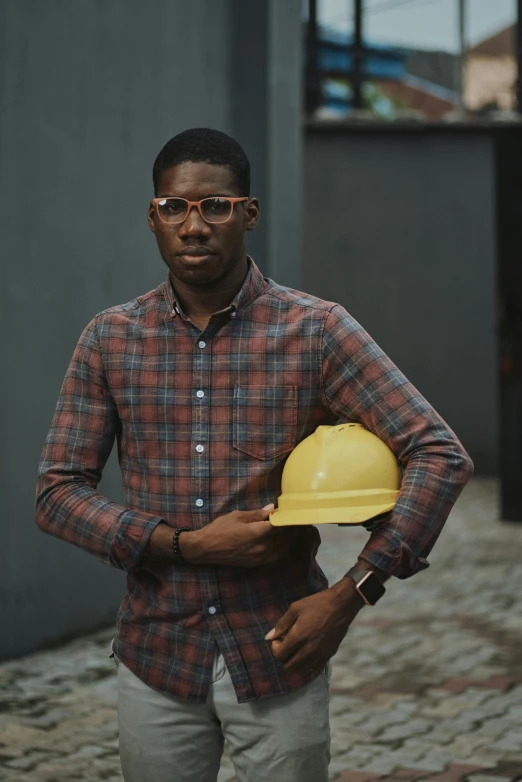 a man in a plaid shirt holding a hard hat, by Chinwe Chukwuogo-Roy, pexels contest winner, renaissance, wearing a suit and glasses, 2 2 years old, promotional image, portrait of tall
