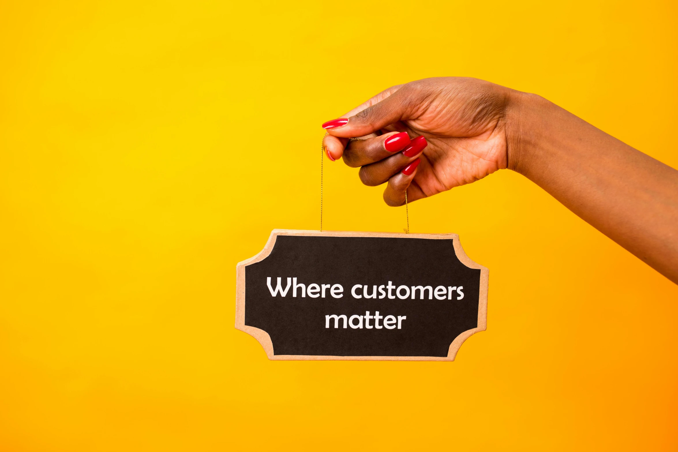 a woman's hand holding a sign that says where customers matter, an album cover, pexels, yellow, panel, diversity, uk