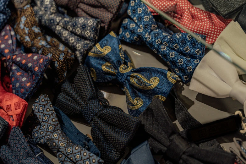 a pile of ties sitting on top of a table, a picture, unsplash, renaissance, ornamental bow, patterned clothing, navy, avatar image