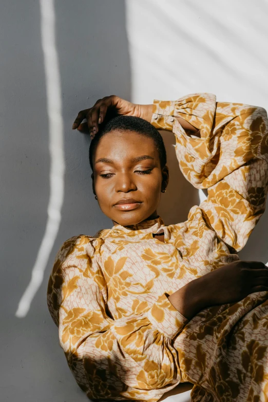 a woman sitting on a chair with her hands behind her head, by Dulah Marie Evans, trending on pexels, renaissance, wearing yellow floral blouse, brown skin. light makeup, portrait of a woman sleeping, big cheekbones