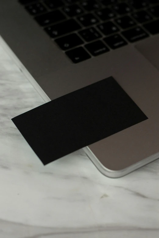 a laptop computer sitting on top of a marble table, minimalist sticker, vantablack, whole card, no - text no - logo