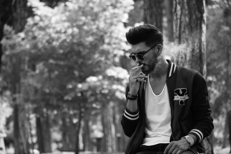 a man sitting on a bench smoking a cigarette, a black and white photo, by Niyazi Selimoglu, pexels, romanticism, undercut hairstyle, : 5 stylish, pompadour, spring season