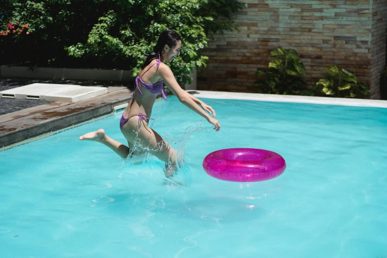 a woman in a bikini playing with a frisbee in a pool, pexels contest winner, magenta, circular shape, b - roll, medium