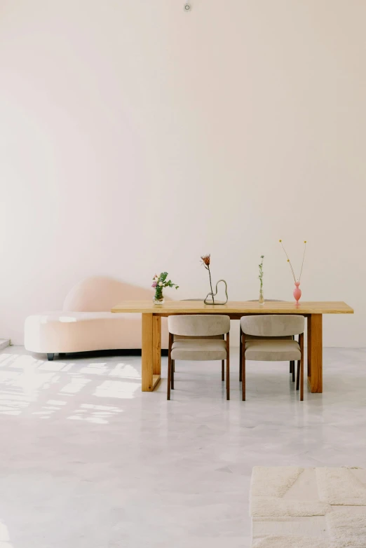 a living room filled with furniture and a wooden table, inspired by Constantin Hansen, unsplash, minimalism, pink concrete, long table, sitting in an empty white room, dwell