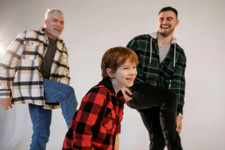 a man standing next to a boy on a skateboard, an album cover, inspired by John Opie, pexels contest winner, wearing a plaid shirt, 3 actors on stage, in a photo studio, happy family