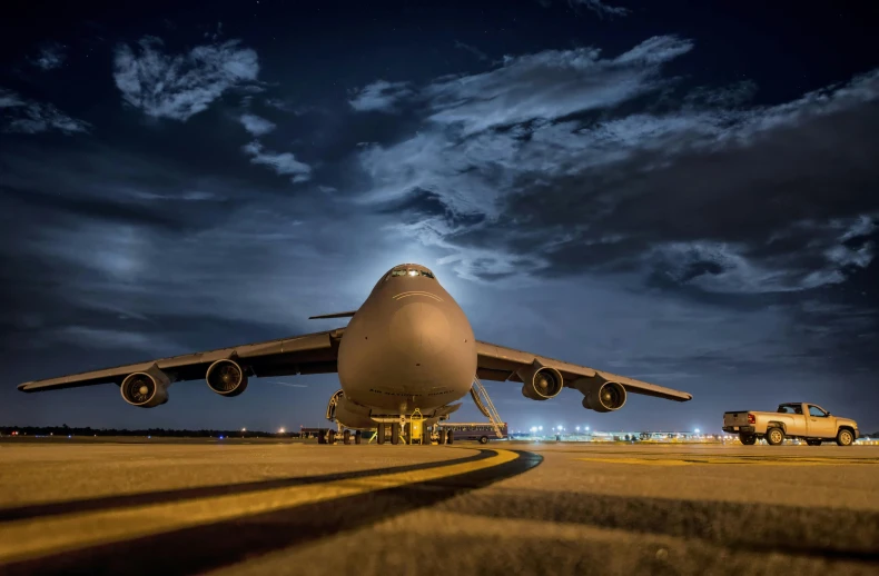 a large jetliner sitting on top of an airport tarmac, a picture, by Jay Hambidge, pexels contest winner, it's night, gigantic landing pad, closeup portrait shot, plain background