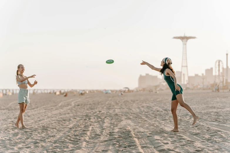 two women are playing frisbee on the beach, an album cover, unsplash contest winner, arabesque, seattle completely wasted away, city views, youtube thumbnail, urban playground