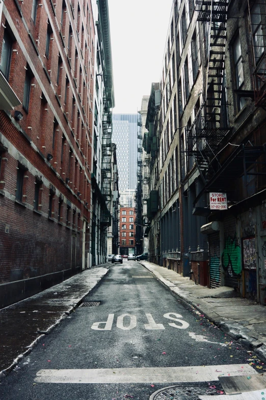 a city street filled with lots of tall buildings, a picture, inspired by Thomas Struth, unsplash contest winner, graffiti, new york alleyway, blank stare”, trending on vsco, cobblestone streets