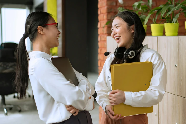 a couple of women standing next to each other, trending on pexels, happening, asian human, schools, smiling at each other, professional image