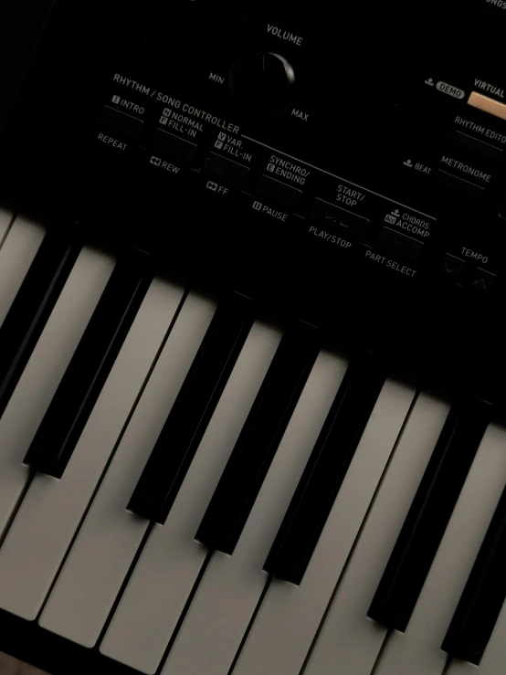 a close up of a keyboard on a table, standing on top of a piano, dark and beige atmosphere, promo image, pitch black background