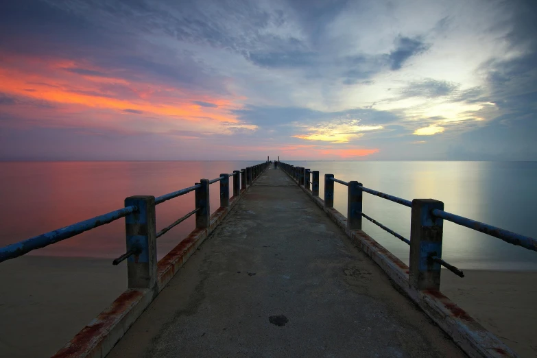 a pier stretching out into the ocean at sunset, mansik yang, multi - coloured, grey