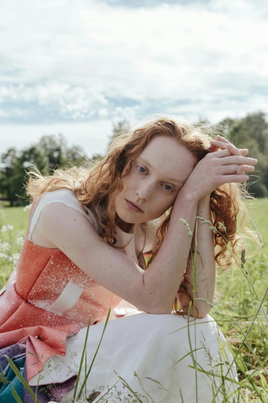 a beautiful young woman sitting on top of a lush green field, an album cover, by Anita Malfatti, renaissance, eleanor tomlinson, medium format. soft light, pale red, with a white complexion