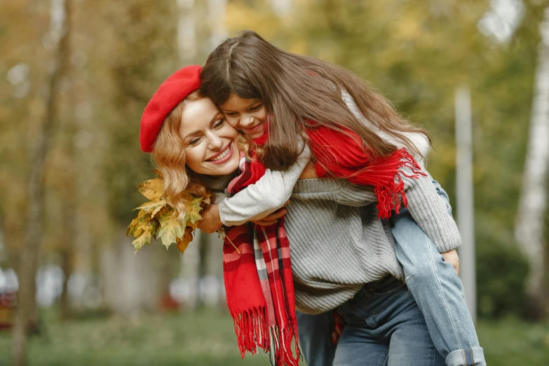 a woman carrying a little girl on her back, pexels contest winner, red ascot and a field cap, 🍂 cute, casual game, red scarf