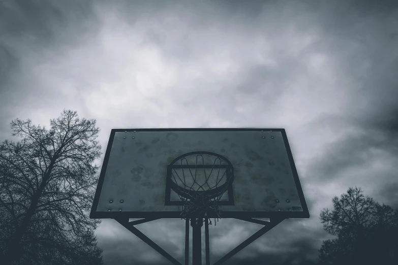 a black and white photo of a basketball hoop, an album cover, unsplash contest winner, realism, overcast gray skies, ( apocalyptic ) 8 k, hq 4k phone wallpaper, holding court