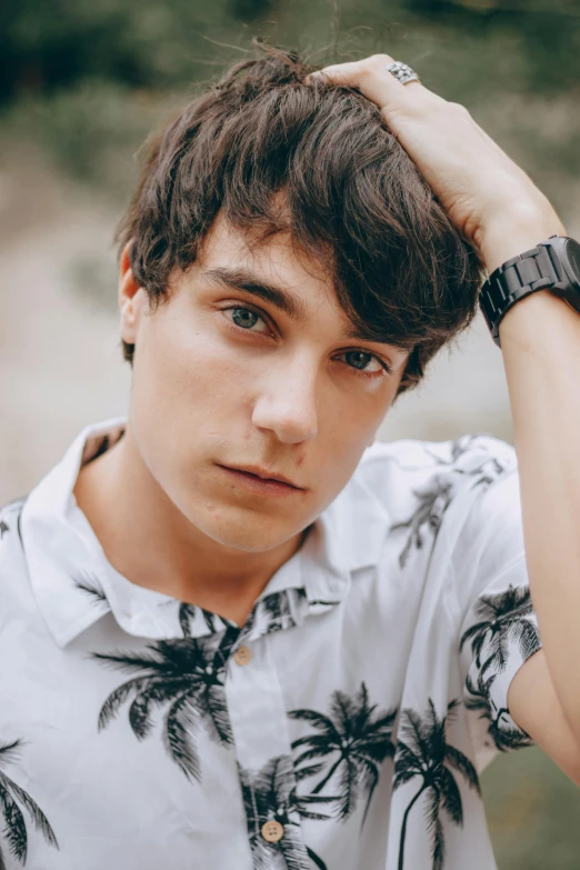 a young man wearing a white shirt with palm trees on it, inspired by John Luke, trending on pexels, a handsome man，black short hair, patterned clothing, heath clifford, pouty