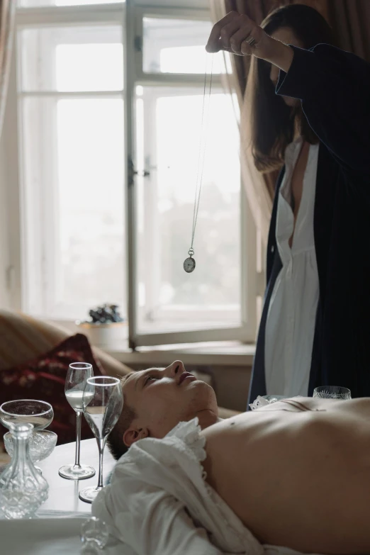 a woman getting a facial massage in front of a window, inspired by Elsa Bleda, renaissance, embedded with gemstones, necromancer sitting at table, victoria siemer, belly button showing