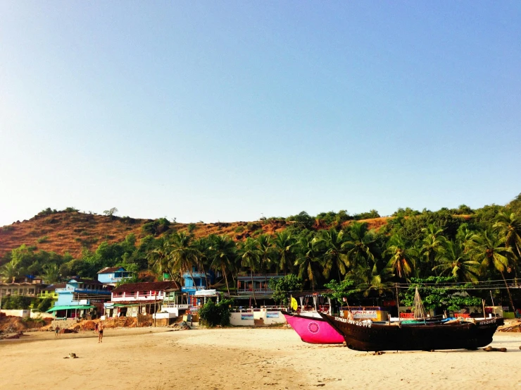 a pink boat sitting on top of a sandy beach, view of villages, indigo, conde nast traveler photo