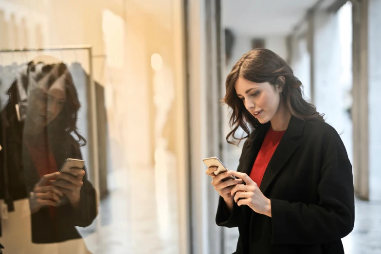 a woman is looking at her cell phone, trending on pexels, renaissance, people shopping, avatar image, professional photo, wearing black coat