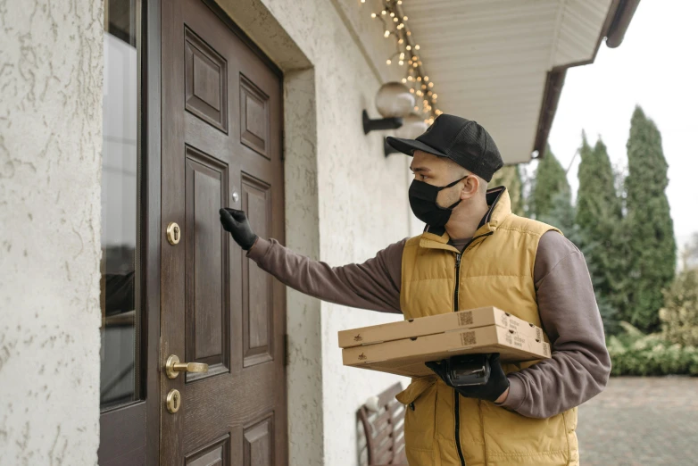 a man wearing a face mask opening a door, pexels contest winner, delivering packages for amazon, holding pizza, avatar image, brown