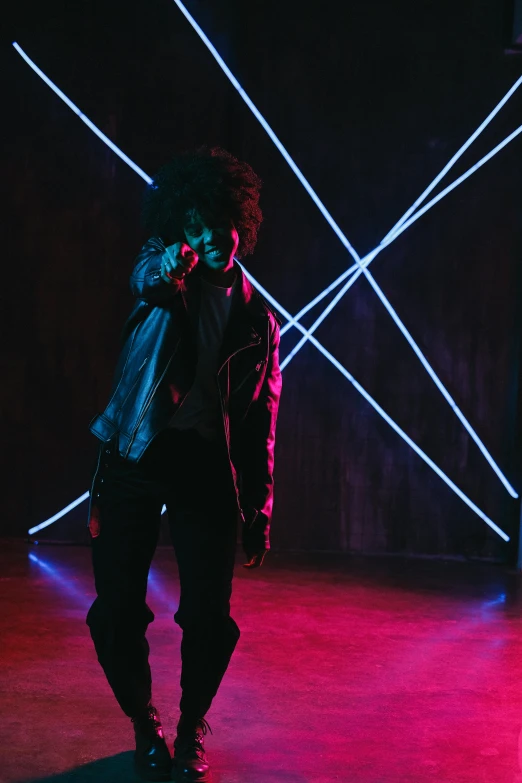 a man standing in front of neon lights, black man with afro hair, gunplay, standing sideways, evenly lit