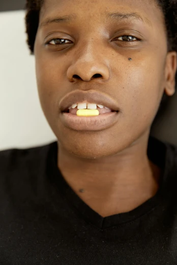a woman with a toothbrush in her mouth, an album cover, unsplash, hurufiyya, offering the viewer a pill, yellow skin, photo in style of tyler mitchell, photographed for reuters