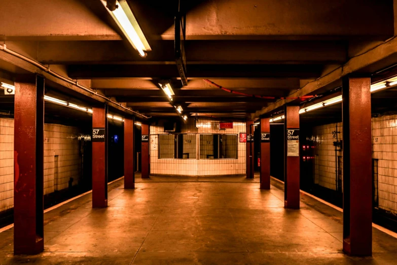 a long hallway leading to a subway station, inspired by Elsa Bleda, unsplash, madison square garden, dimly lit underground dungeon, panoramic, ignant