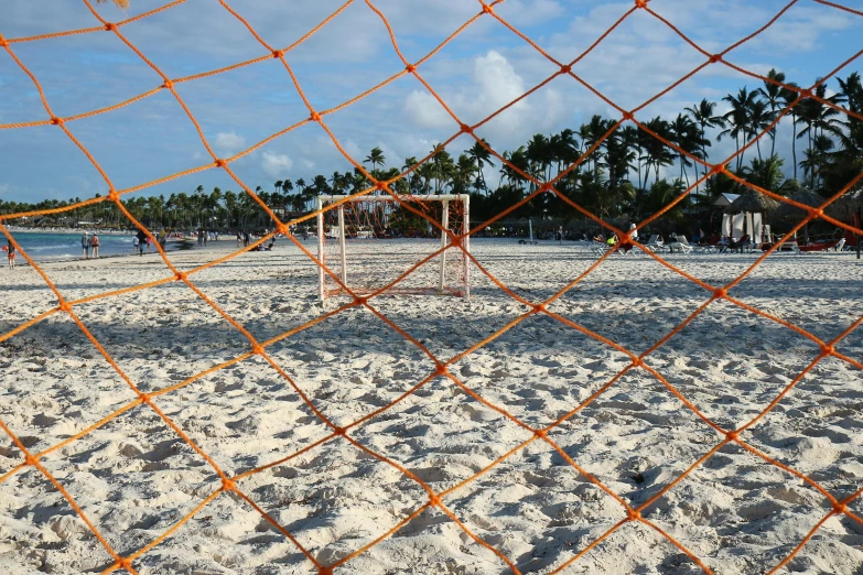 a soccer goal sitting on top of a sandy beach, by Gina Pellón, unsplash contest winner, temporary art, square, tropics, netting, orange grass