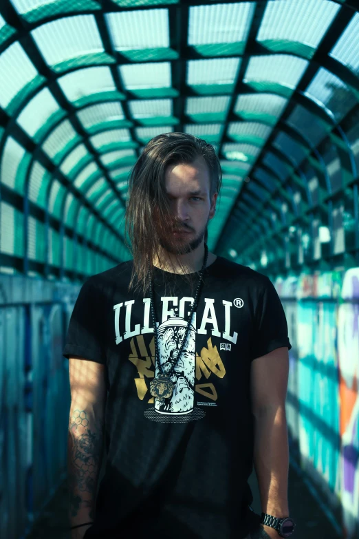 a man with long hair standing in a tunnel, an album cover, inspired by Willem Labeij, unsplash, graffiti, he is wearing a black t-shirt, mugshot, pewdiepie, regal clothing