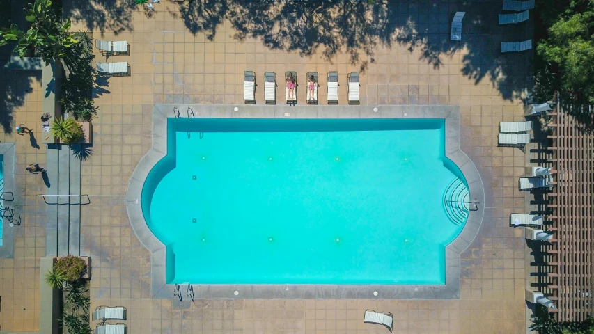 an aerial view of a swimming pool surrounded by lounge chairs, a portrait, pexels contest winner, square, marbella, symmetry!! water, apartment