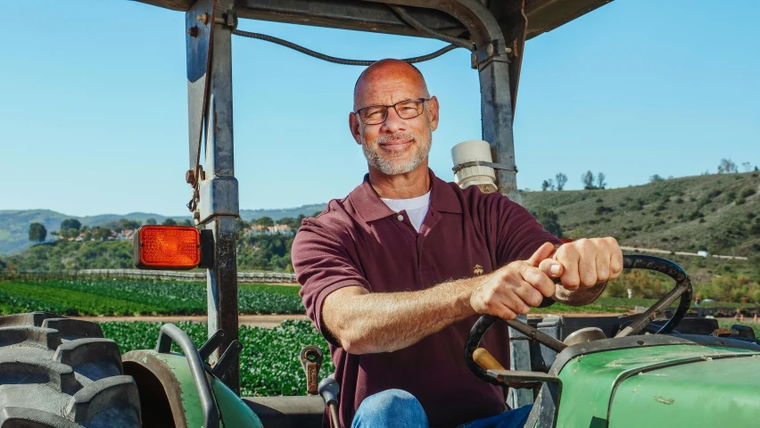 a man sitting in the driver's seat of a tractor, a portrait, by Steve Brodner, renaissance, portrait image, blippi, hollister ranch, bald on top